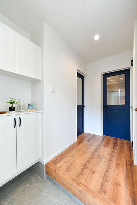 白を基調とした玄関にブルーの扉がアクセント｜京都・滋賀の注文住宅 天然木の家