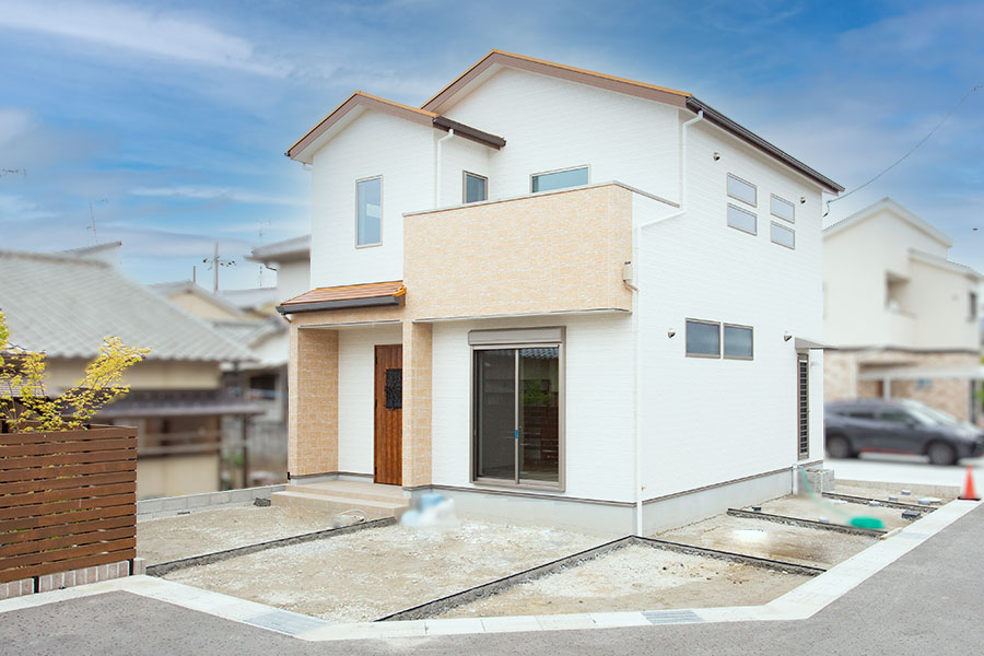 白の外壁にオレンジの屋根とレンガ調のアクセントがかわいい外観｜京都・滋賀の注文住宅 天然木の家
